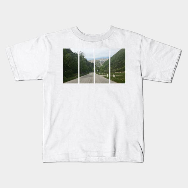 A shot on the move from behind the windshield of an electric car with alps mountains in front of it in a fresh sunny spring day. POV first person view shot on a asphalted mountain road Kids T-Shirt by fabbroni-art